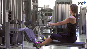 Vídeo formación online. Mujer haciendo ejercicios de pesas en un gimnasio
